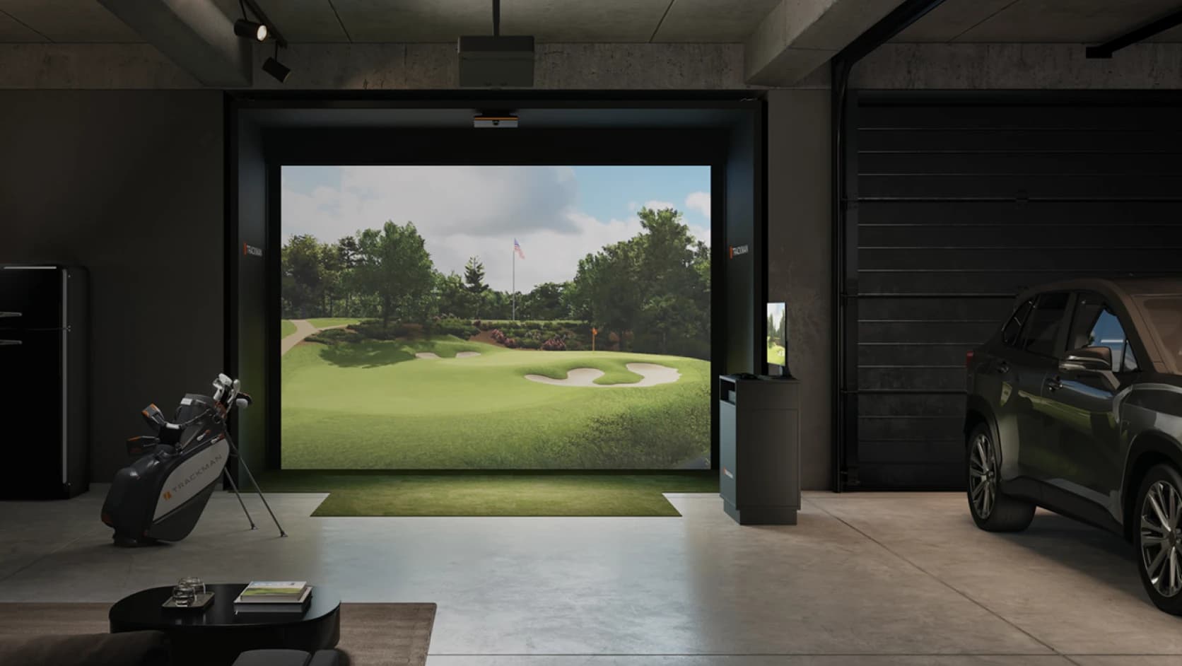 Indoor golf simulator setup in a modern room with a large screen displaying a golf course, golf clubs on a stand, and a parked car.